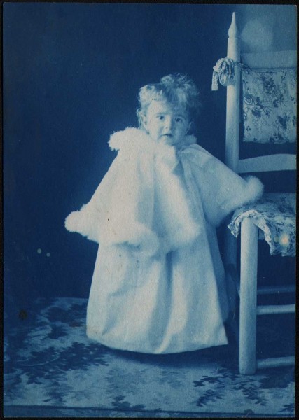 Dorothy Tucker dressed in Fur-Trimmed Coat next to Chair